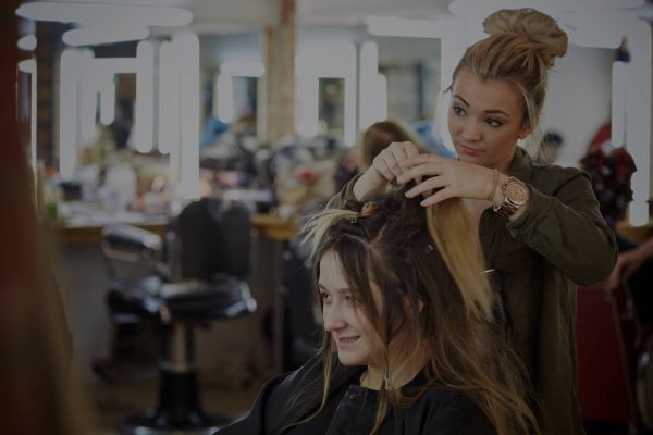 Student demonstrating wig and makeup skills on a student model at Christine Blundell Makeup Academy.